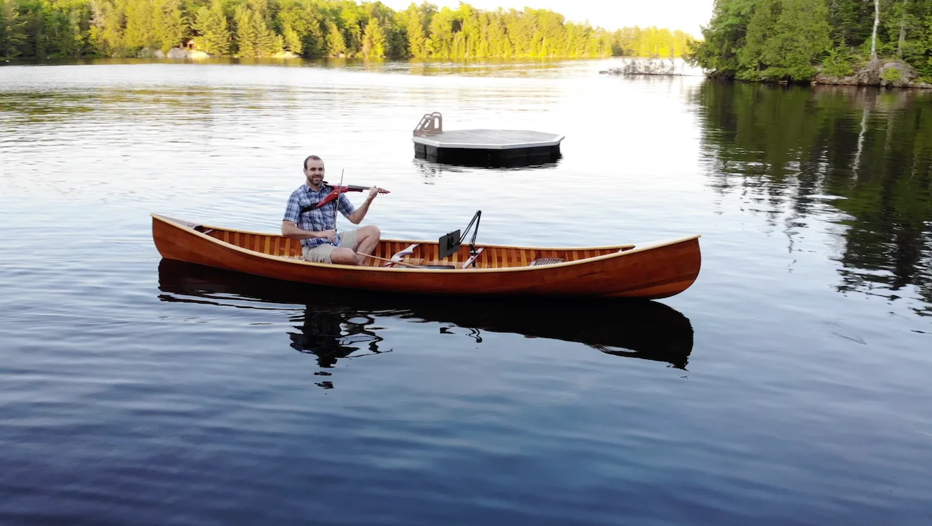 Alan Mallory playing electric violin in a canoe